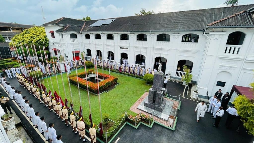 High-angle view of Nalanda College assembly grounds with students lined up in white uniforms